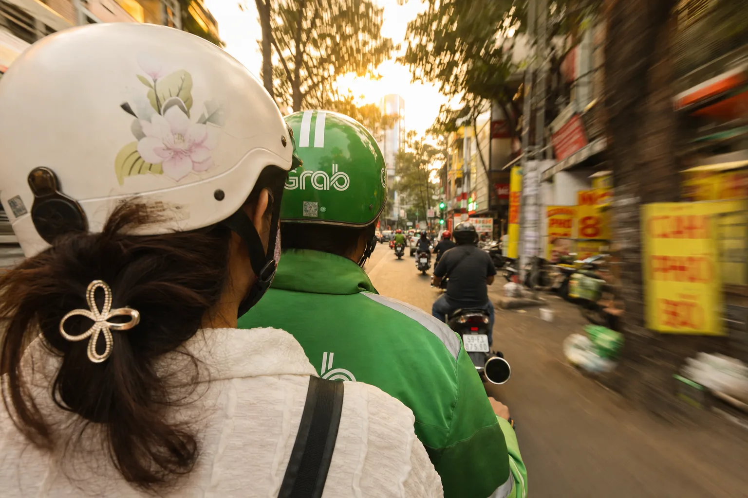 从摩托车后座拍摄的越南街道与 Grab 骑手背影