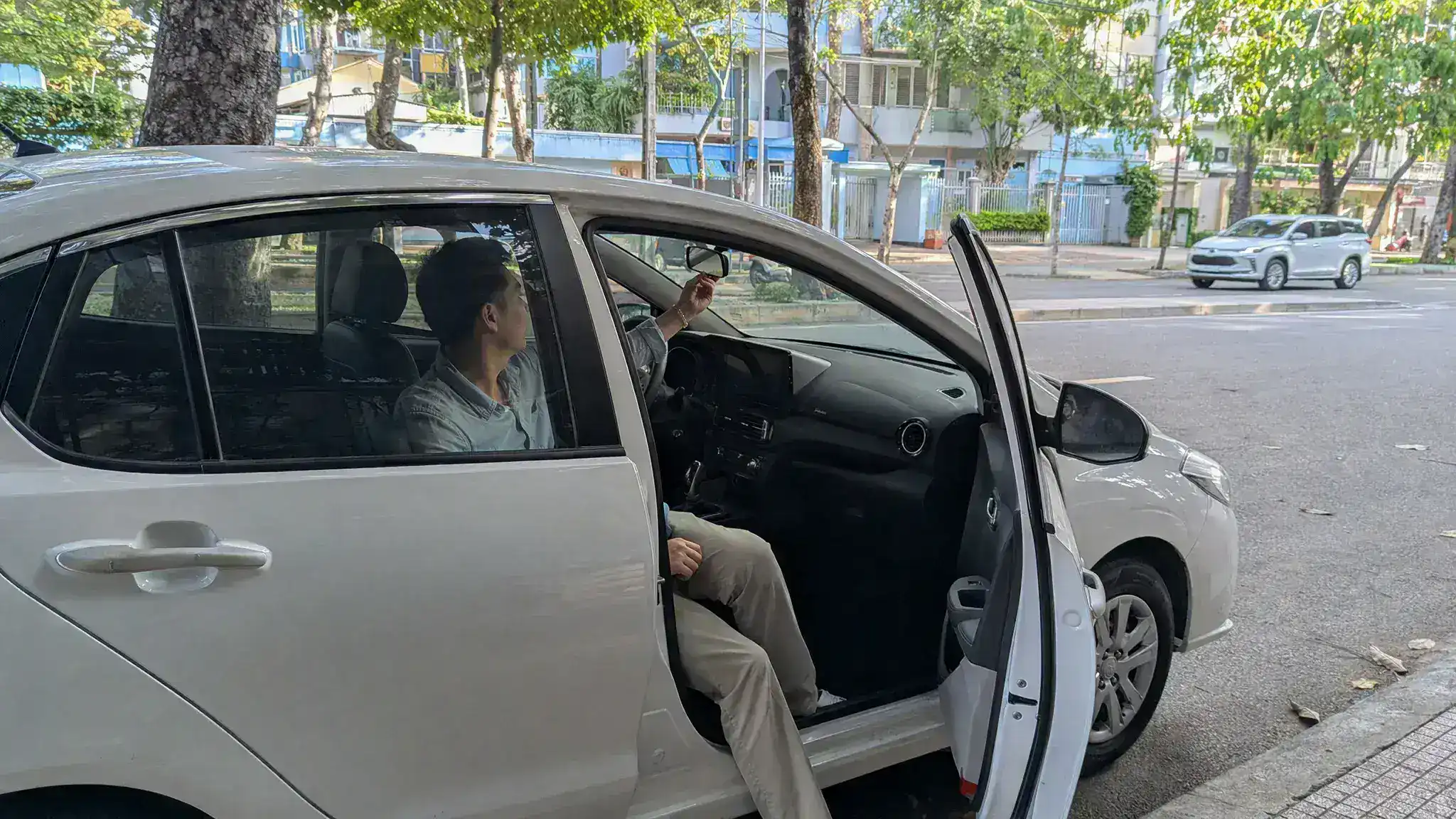 胡志明市街边轿车驾驶位内调整后视镜